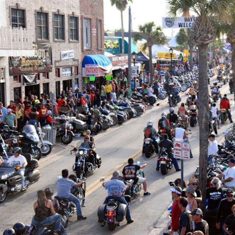 A large group of bikers rides down the street during Daytona Bike Week